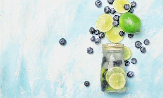 Summer cold drink with blueberry lime and ice in glass bottle top view