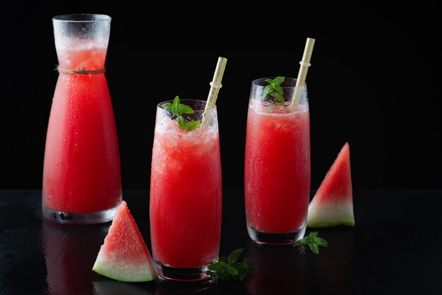 Summer cold drink with watermelon and mint on a black wooden background