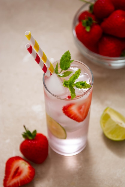 Summer cold refreshing fruit drinks cocktail with strawberry, lime and mint leaves