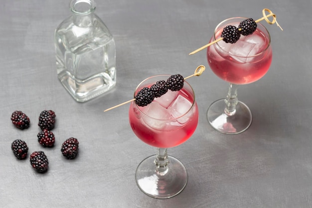 Summer cooling drink in wine glass with ice Blackberry on skewer on wine glass