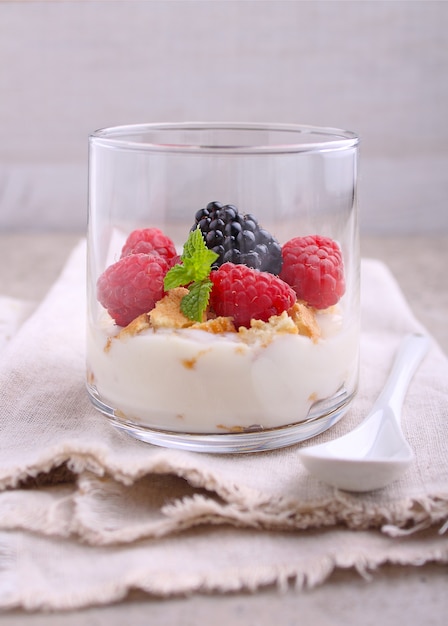 Summer dessert with berries cream and cookies in glasses