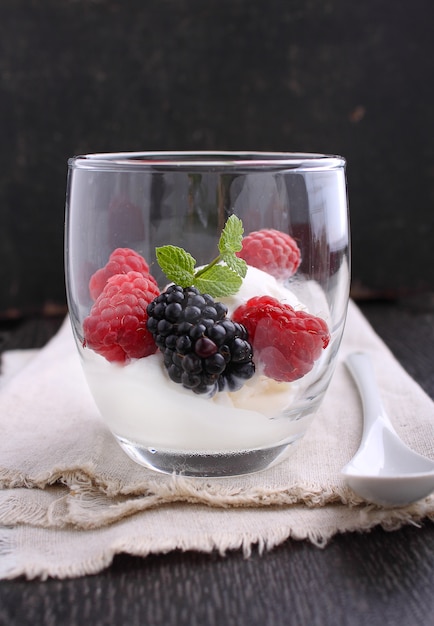 Summer dessert with berries and ice cream in glasses on a black background