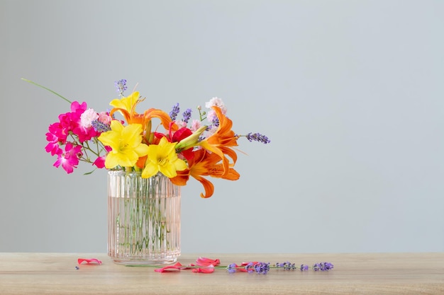 summer flowers in glass vase on wooden shelf