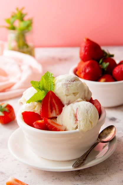 Summer food. Strawberry ice cream scoops in bowl with fresh strawberry fruits. Delicious fresh dessert