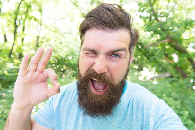 Photo summer fun bearded guy in park forest bearded hipster hipster with long beard emotional face close up nature background crazy bearded mature man in natural environment brutal male leisure