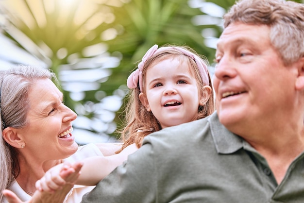 Summer fun and grandparents with girl in the park enjoying weekend holiday and quality time Family love and child playing in garden with grandma and grandfather bonding and having fun in nature