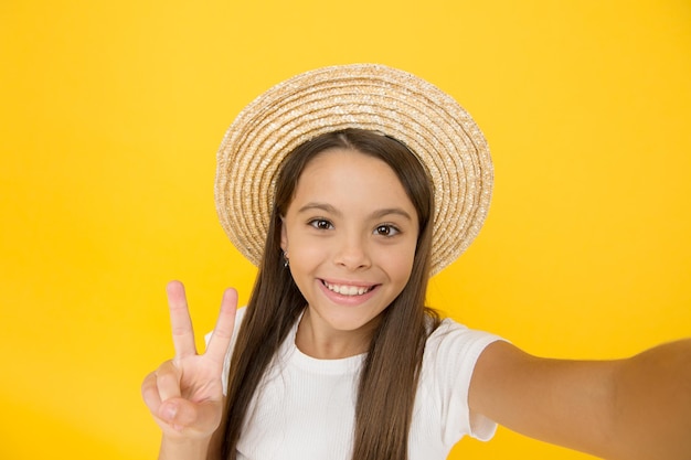 Summer fun. teen girl greeting summer. little beauty in straw hat make selfie. beach style for kids. happy summer vacation. relax and have fun. travel to hawaii. aloha. retro child. she loves vintage.