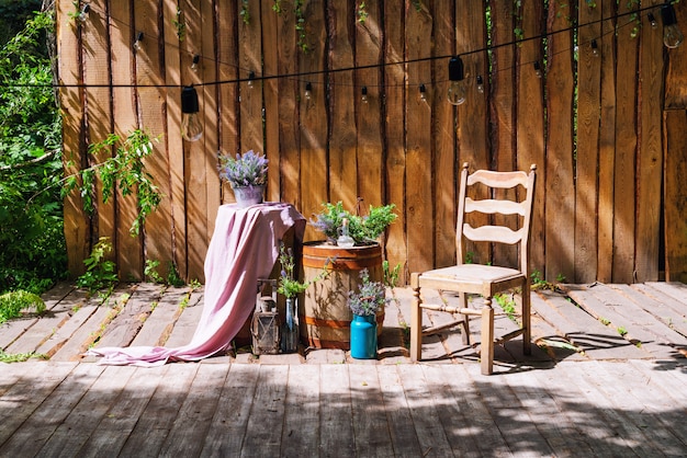 Summer garden with wooden stage and garland of lights