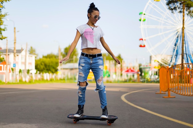 Summer  the girl in the Park riding a skateboard