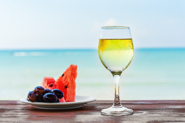 Summer, a glass of champagne and fruit against the background of the sea