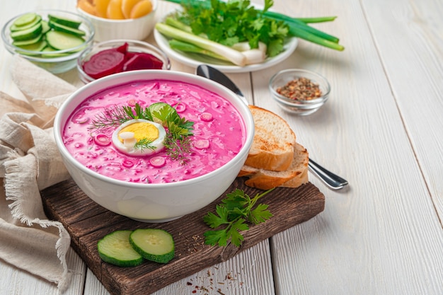 Summer healthy beetroot soup with egg on a white background with space to copy