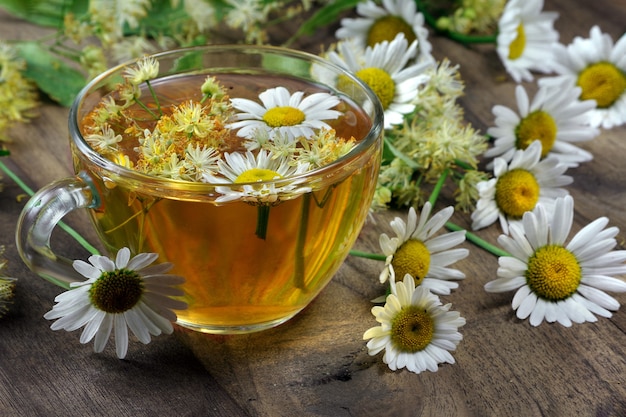 Summer herbal tea. linden and chamomile tea on a wooden table.