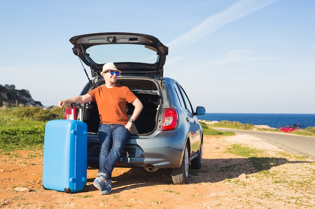 Summer, holiday, trip and vacation concept - Man near the car ready to travel.