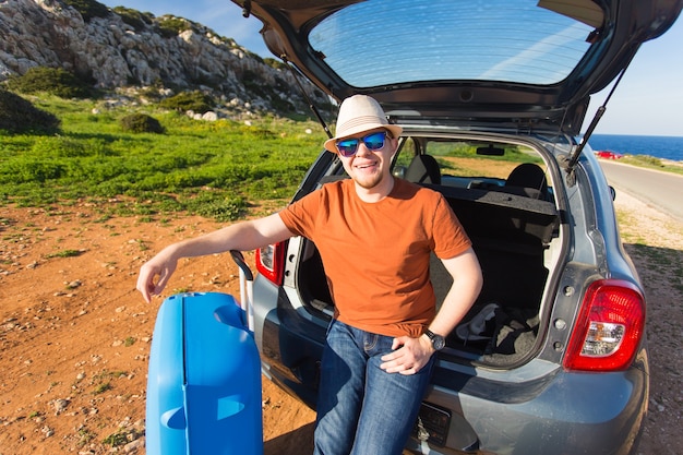 Summer, holiday, trip and vacation concept. Man near the car ready to travel.