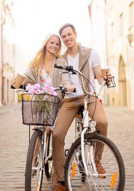 summer holidays, bikes, love, relationship and dating concept - couple with bicycles in the city