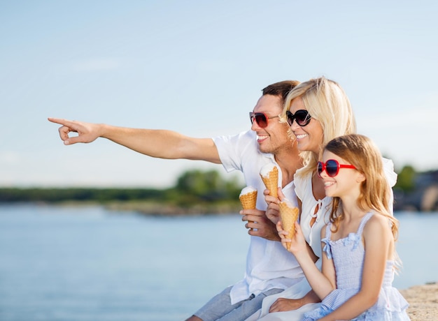 summer holidays, celebration, children and people concept - happy family eating ice cream