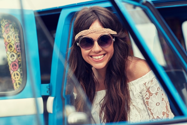 summer holidays, road trip, vacation, travel and people concept - smiling young hippie women in minivan car