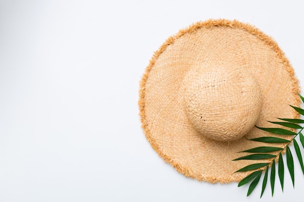 Summer holidays Summer concept with straw hat and tropical leaf Flat lay top view copy space