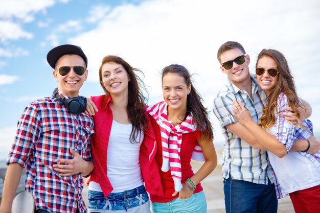 summer holidays and teenage concept - group of smiling teenagers hanging outside