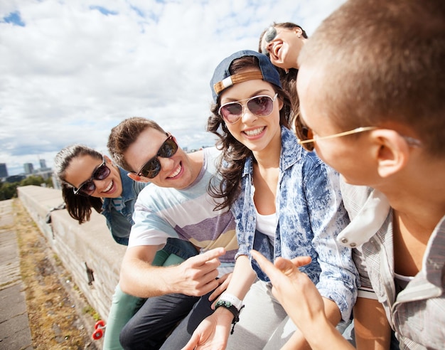 summer holidays and teenage concept - group of teenagers hanging out outside