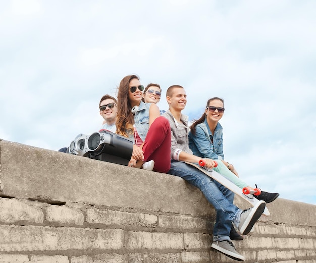 summer holidays and teenage concept - group of teenagers hanging outside