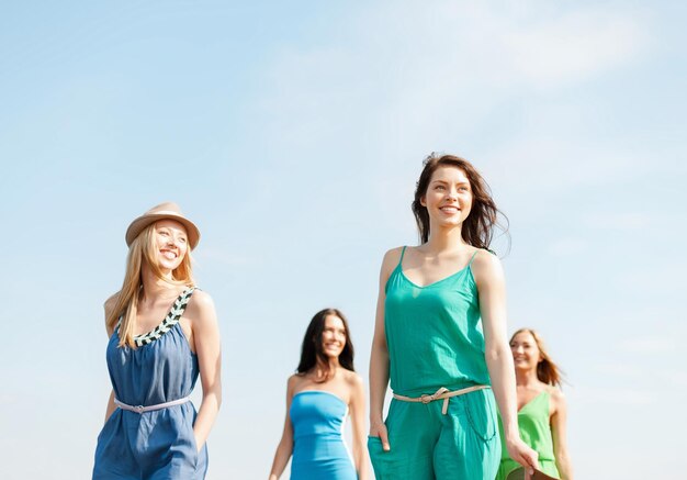 summer holidays and vacation concept - smiling girls walking on the beach