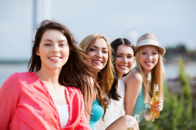 summer holidays and vacation - girls with drinks on the beach