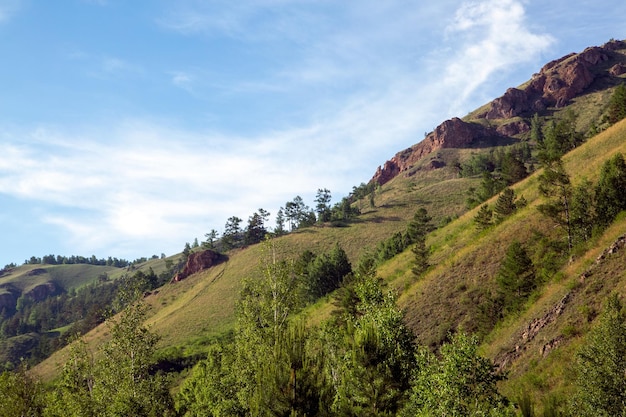 Summer landscape mountains and rocks against a blue sky with clouds with copy space Tourism active recreation