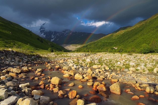 Summer landscape with a rainbow in the mountains. Beauty in nature