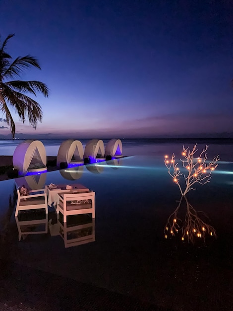 Summer love and romance table set-up for a romantic dinner, infinity pool reflection chairs lights