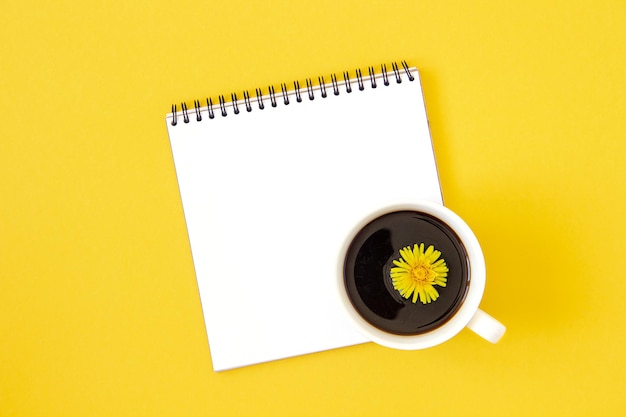 Summer minimal layout made with white blank notebook and cup of coffee on yellow background Mock up in flat style Top view