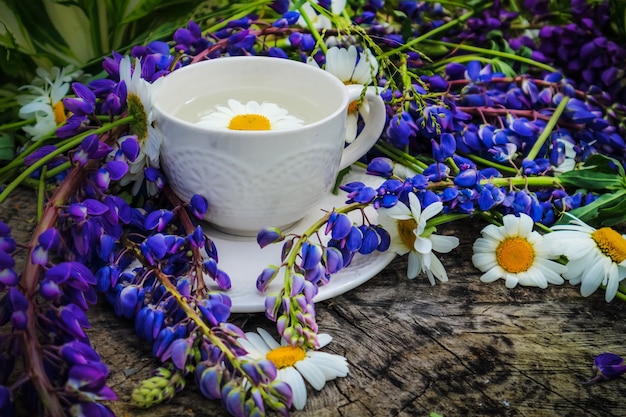 A summer morning ,a white cup of coffee and a bouquet of wild flowers