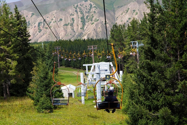 Summer mountain landscape high in the mountains Tall trees of Christmas trees ski lift at the ski base