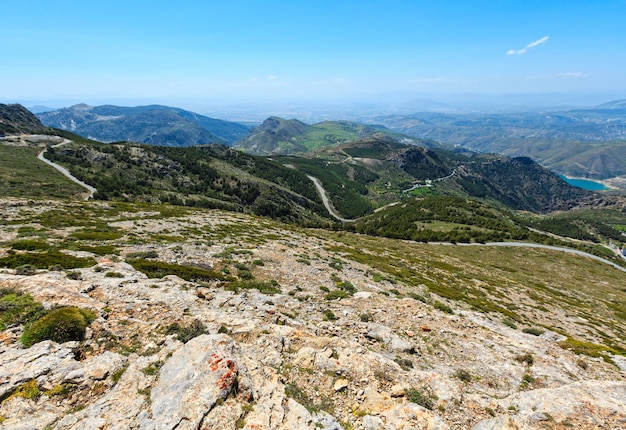 Summer mountain landscape with alpine road and lake (Sierra Nevada National Park, near Granada, Spain).