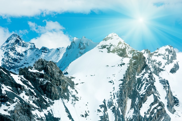 Summer mountain view from Stelvio pass (Italy) with snow on slope and sunshine in blue sky