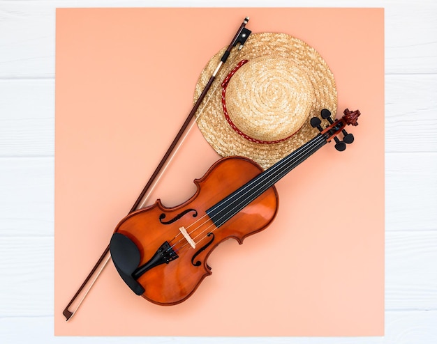 Summer music vacation background violin and straw hat on white background with space for your text