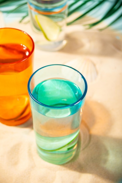 Summer non alcoholic cocktails in colorful glasses on beach with white sand Summer sea ocean vacation and travel concept