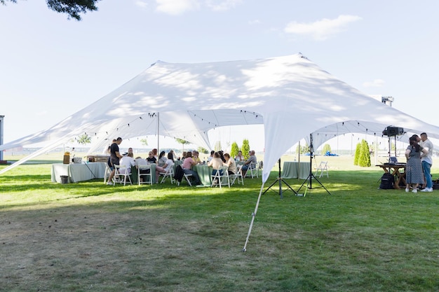 Summer party on a green lawn under a white tent Horizontal photo Minsk Belarus August 15 2022