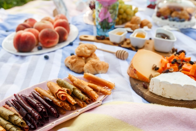 Summer picnic blanket with tasty food and snacks on it. Summer weekends