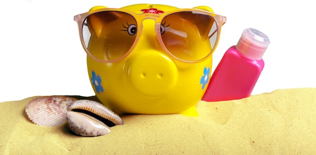 Summer piggy bank with sunglasses on the beach