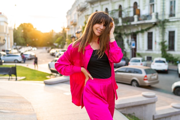 Summer portrait of playful good-looking woman in stylish pink jacket.