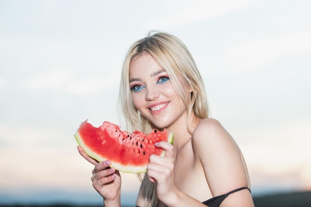 Summer portrait woman is holding a slice of watermelon