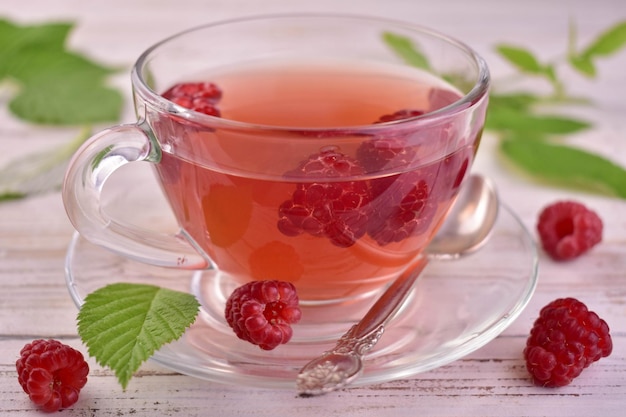 Summer raspberry tea in a transparent cup vintage wooden background