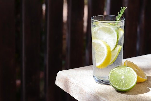 Summer refreshing lemonade and ingredients on light table outdoors space for text