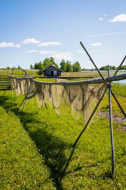 Summer rural landscape drying fishing nets in the fresh air on the shore of the lake