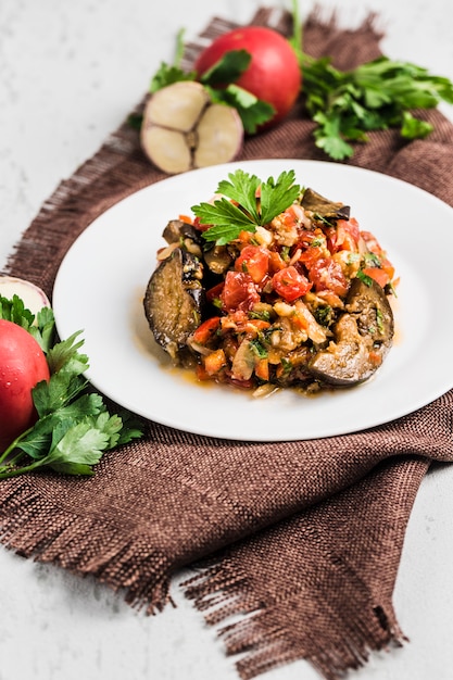 Summer salad of eggplant and tomato on a white plate