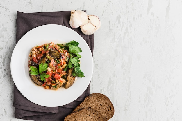 Summer salad of eggplant and tomato on a white plate