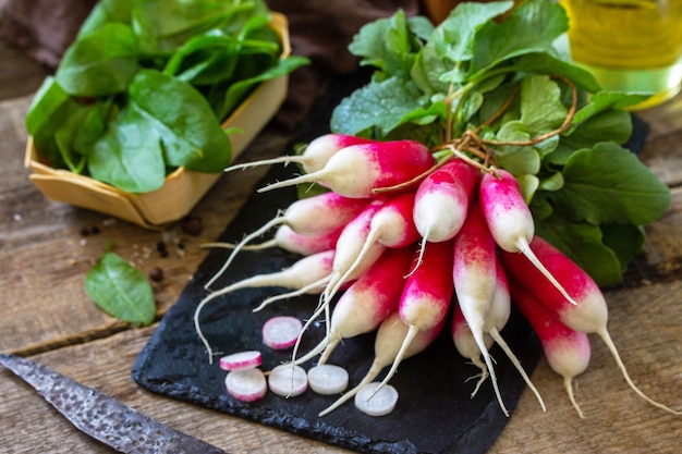 Summer salad ingredients organic vegetables and olive oil Raw fresh juicy radish on a rustic table