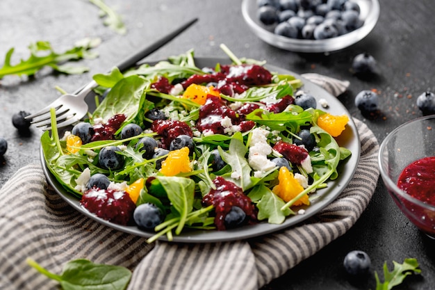 Summer salad with salad leaves, fruits, berries and cheese