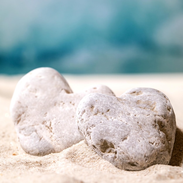 Summer sand sea beach with waves and heart stones